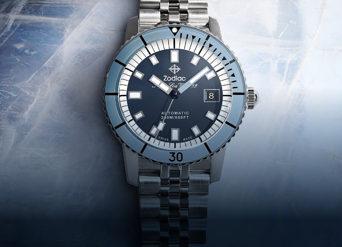 Detail shot of a Super Sea Wolf Compression Diver watch with a baby blue bezel and a dark blue dial against an icy background