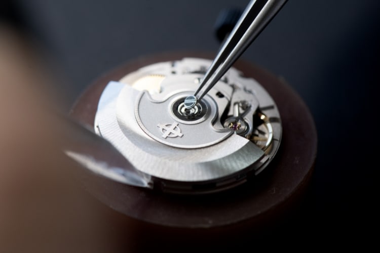Watch craftsman examining a watch.
