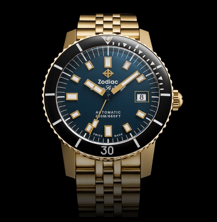 Detail shot of a Super Sea Wolf Compression Diver watch featuring an 18K gold-plated case and five-link bracelet, a deep sea blue sunray dial and a black ceramic rotating bezel.