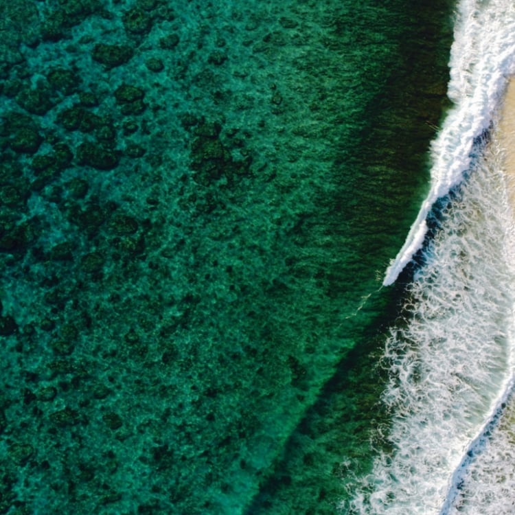 Arial view of ocean waves crashing against the shoreline.