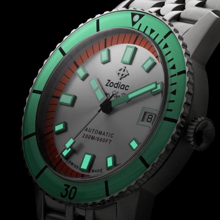 Close up of a Super Sea Wolf Compression Diver watch with an orange and silver sunray dial, and glowing SuperLumiNova® hands and markers