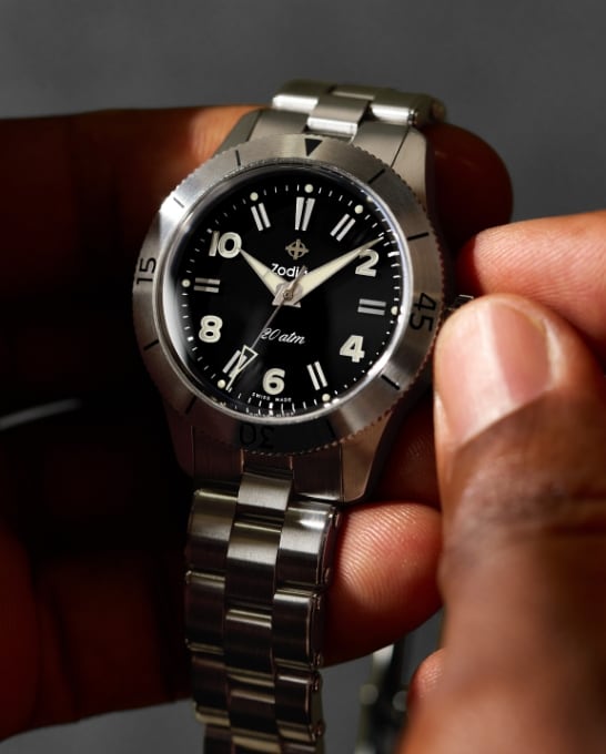 A Zodiac watchmaker meticulously works on a watch.