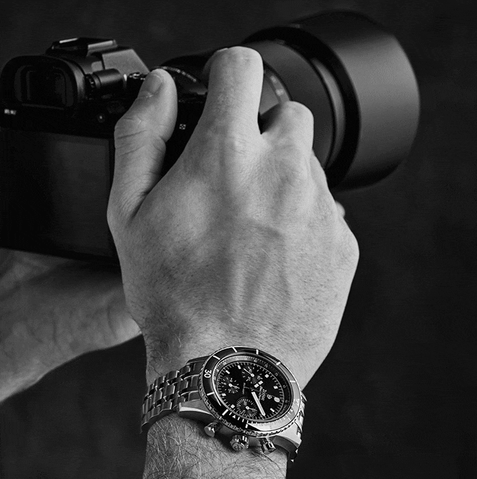 GIF of a male model wearing a Zodiac watch while taking photographs. 