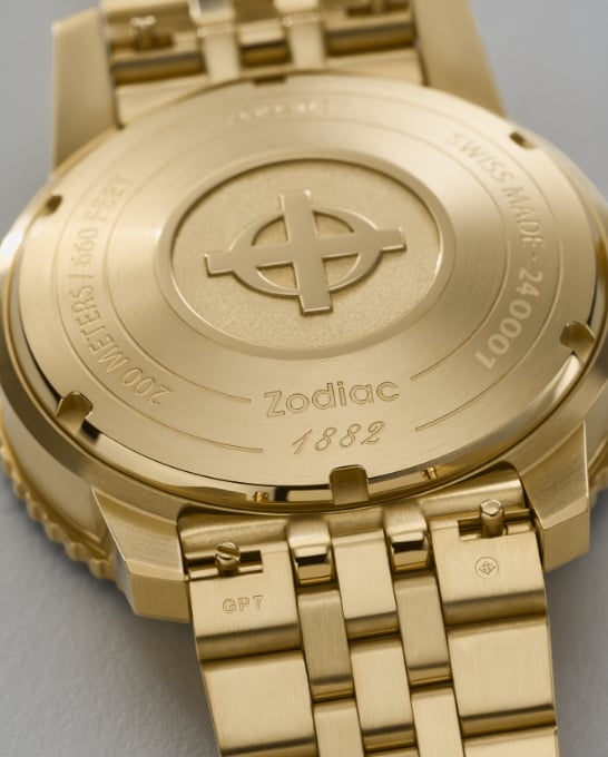 Detail shot of a Super Sea Wolf Compression Diver watch featuring an 18K gold-plated case and five-link bracelet, a deep sea blue sunray dial and a black ceramic rotating bezel.