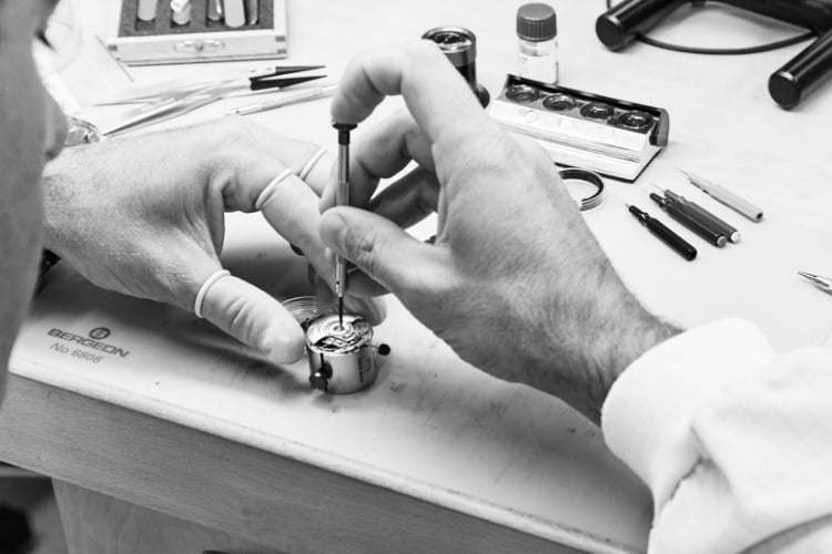 Watch craftsman examining a watch.