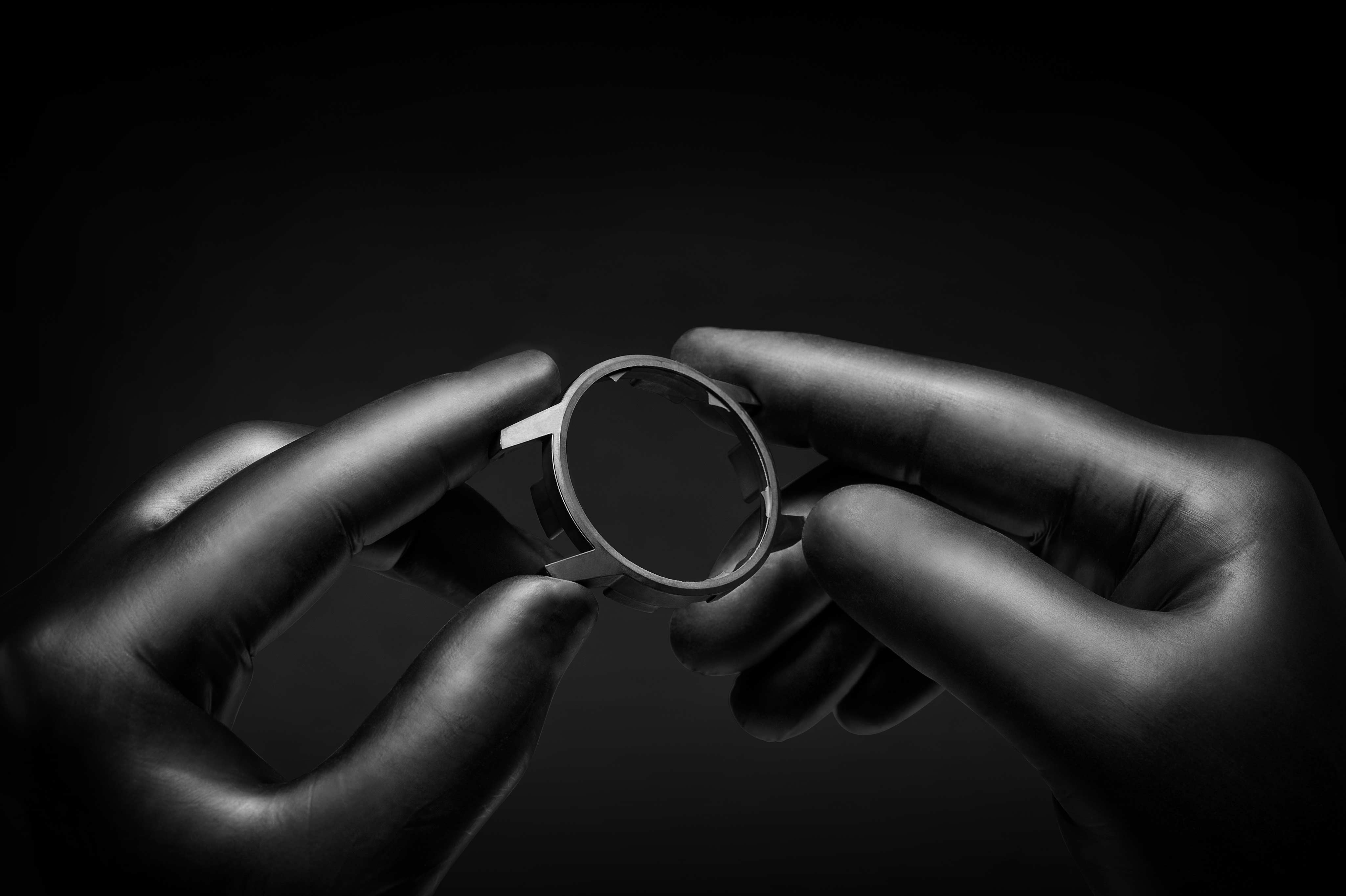 Two hands holding ceramic watch.