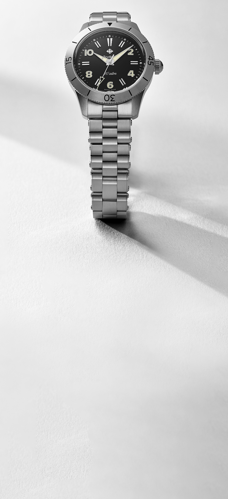 Detail shot of a Super Sea Wolf Compression Diver watch featuring an 18K gold-plated case and five-link bracelet, a deep sea blue sunray dial and a black ceramic rotating bezel.