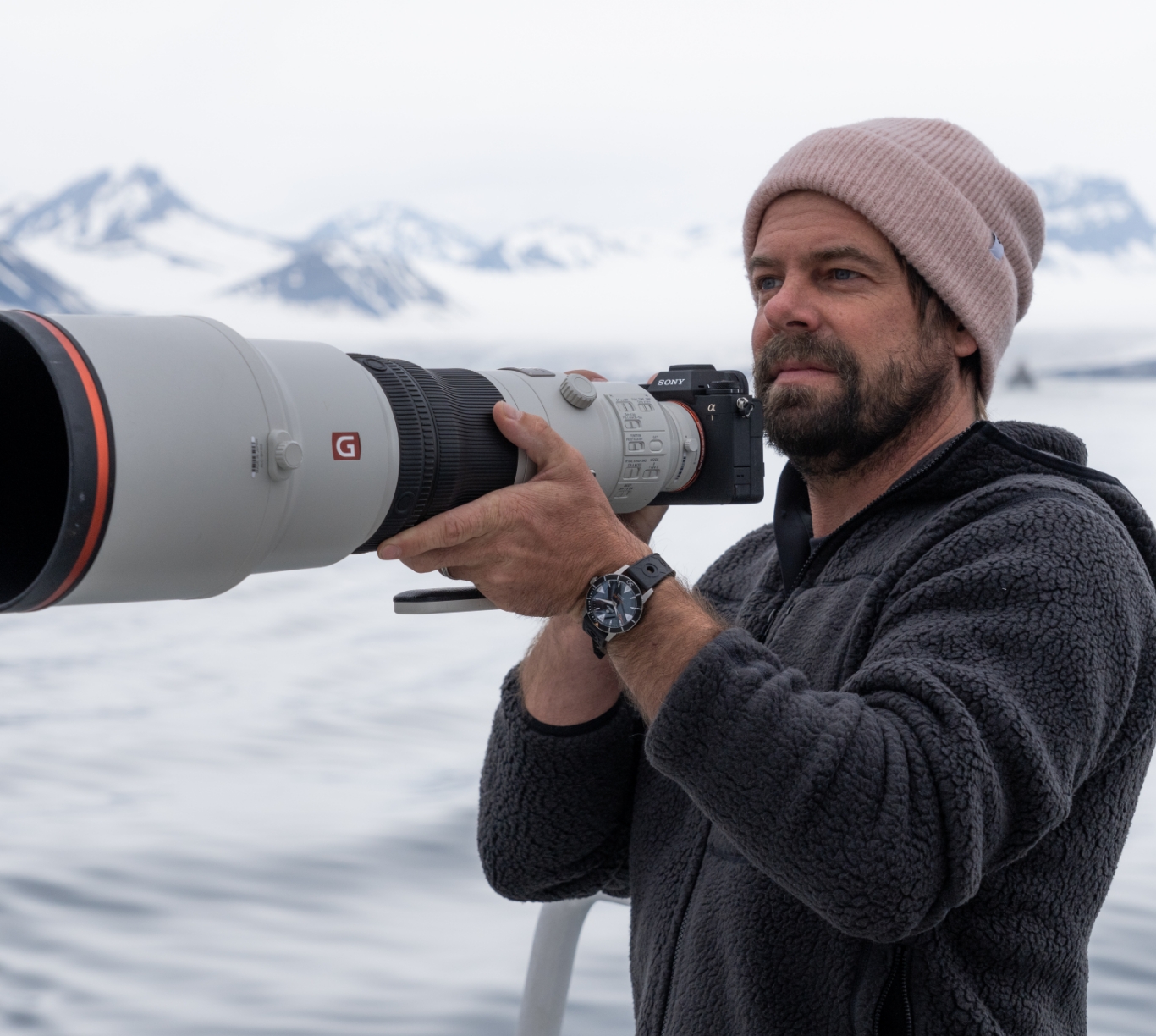 with a camera, wearing a zodiac watch