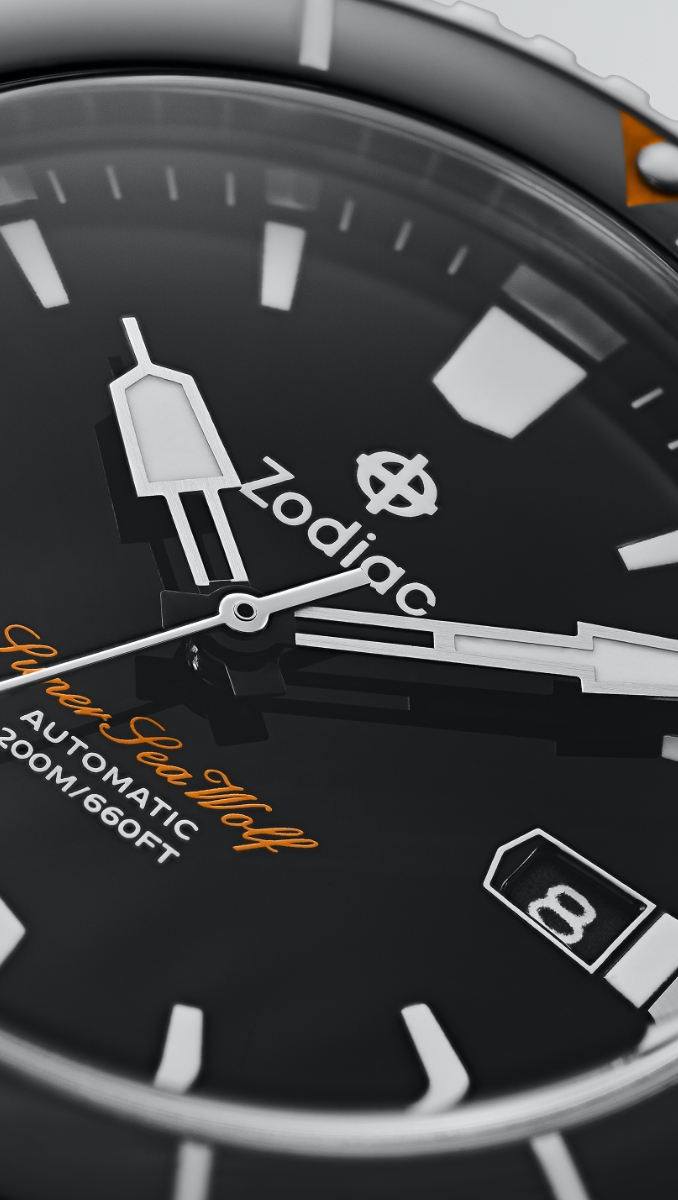 A close up of the watch's hands, indices, date window and black dial. A close up of the watch's hands, indices, date window and black dial.